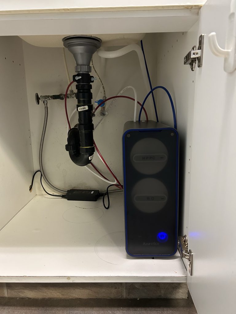 Azuretics 2 in 1 tankless reverse osmosis system model 83802 mounted under a kitchen sink, showing the HPPC cartridge and RO membrane quick-turn caps